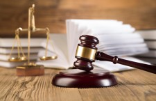 Golden scales of justice, gavel and books wood brown background